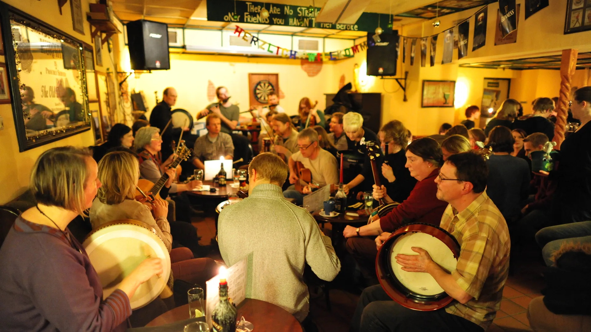 Musicians playing fiddle and bodhrán at an Irish traditional music session