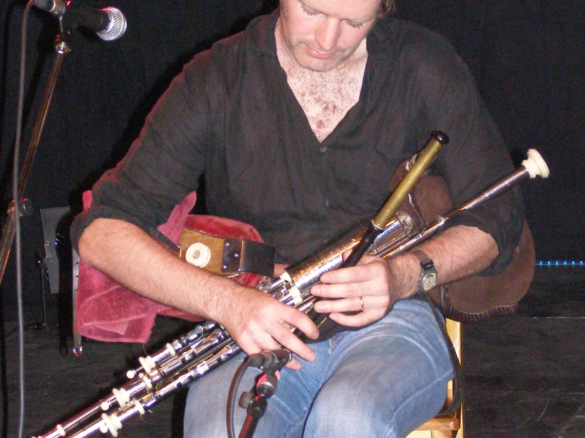 A musician playing the uilleann pipes at a traditional Irish music performance